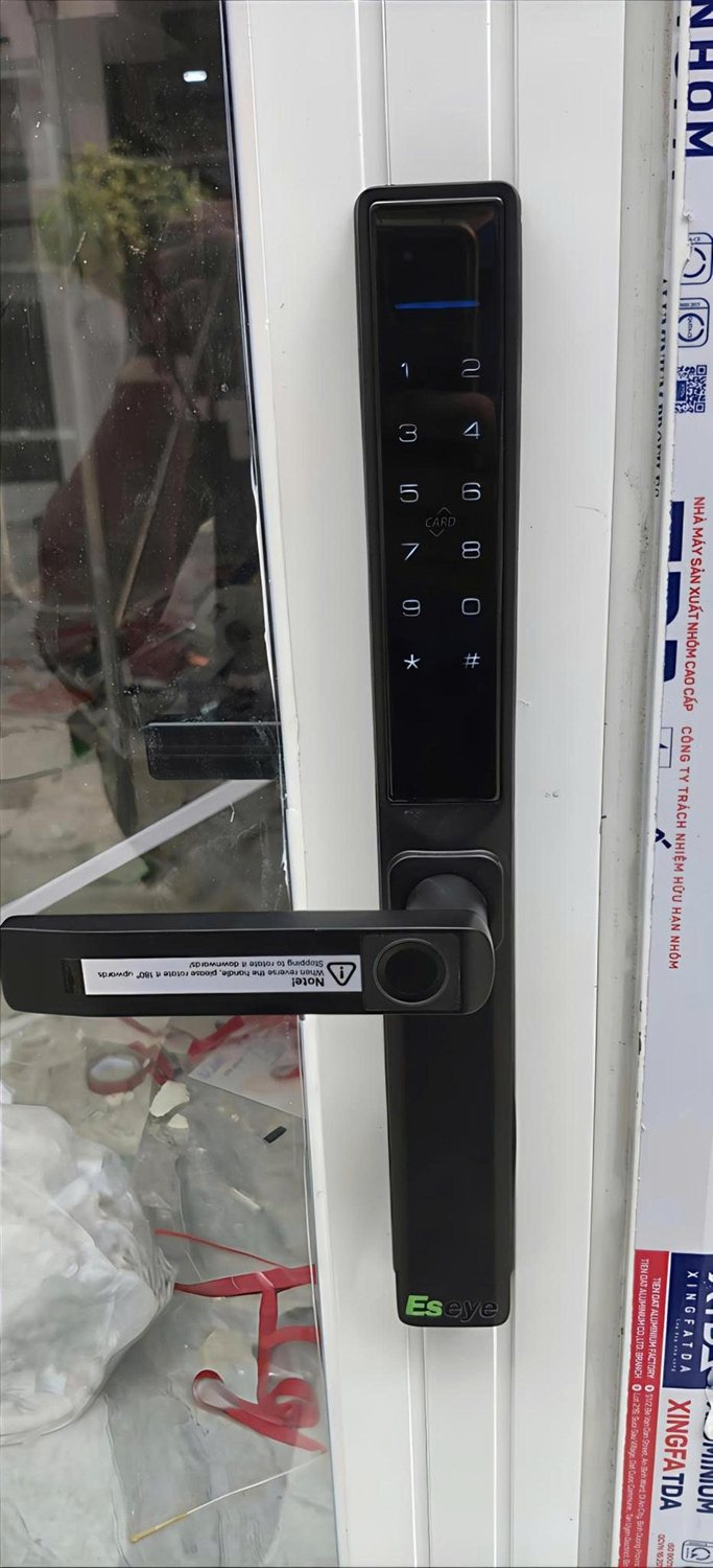 Khóa điện tử thân hẹp trên cửa nhôm kính.